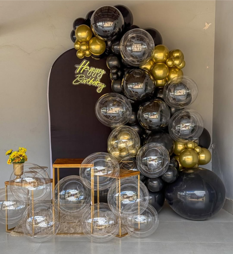 Luxury black and gold birthday decoration with matte black backdrop, bubble balloons, chrome gold balloons and Happy Birthday neon light