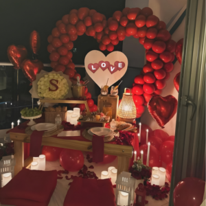 Luxury romantic balcony candlelight dinner setup with heart balloon decoration and picnic dining arrangement