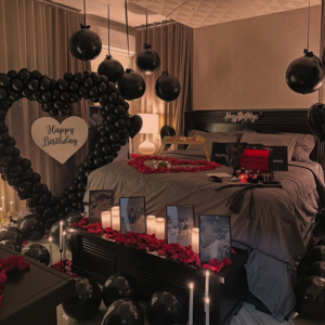 Luxury black theme romantic birthday room decoration with giant heart backdrop, candles and black balloons