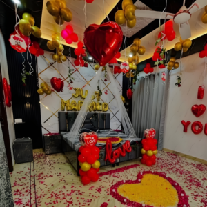Luxury just married room decoration with red and gold balloons, heart balloons and rose petal floral heart setup