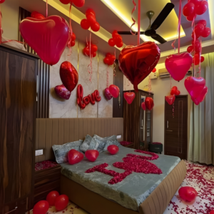 Romantic room decoration with red heart balloons, rose petals, and I love you bed setup