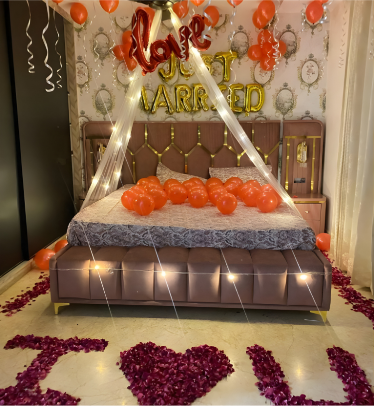 Just married room decoration with balloons, fairy lights canopy and I Love You rose petal decoration