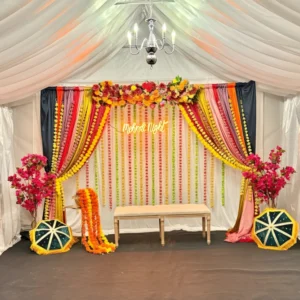 Luxury Mehndi Night Stage Decoration with Floral Backdrop, Colorful Drapes and Traditional Props