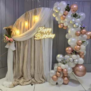 Soft Luxury Birthday Decoration with Fabric Backdrop, Warm Lights and Champagne Balloon Garland