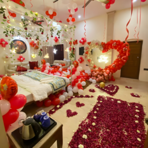 Luxury romantic bedroom decoration with heart balloon arch, fairy lights, rose petal walkway and premium balloon styling