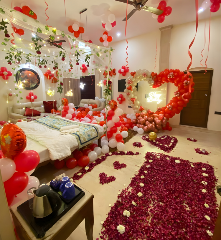 Luxury romantic bedroom decoration with heart balloon arch, fairy lights, rose petal walkway and premium balloon styling