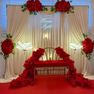 Luxury Henna Night Stage Decoration with Cream Drapes, Red Flowers and Neon Sign