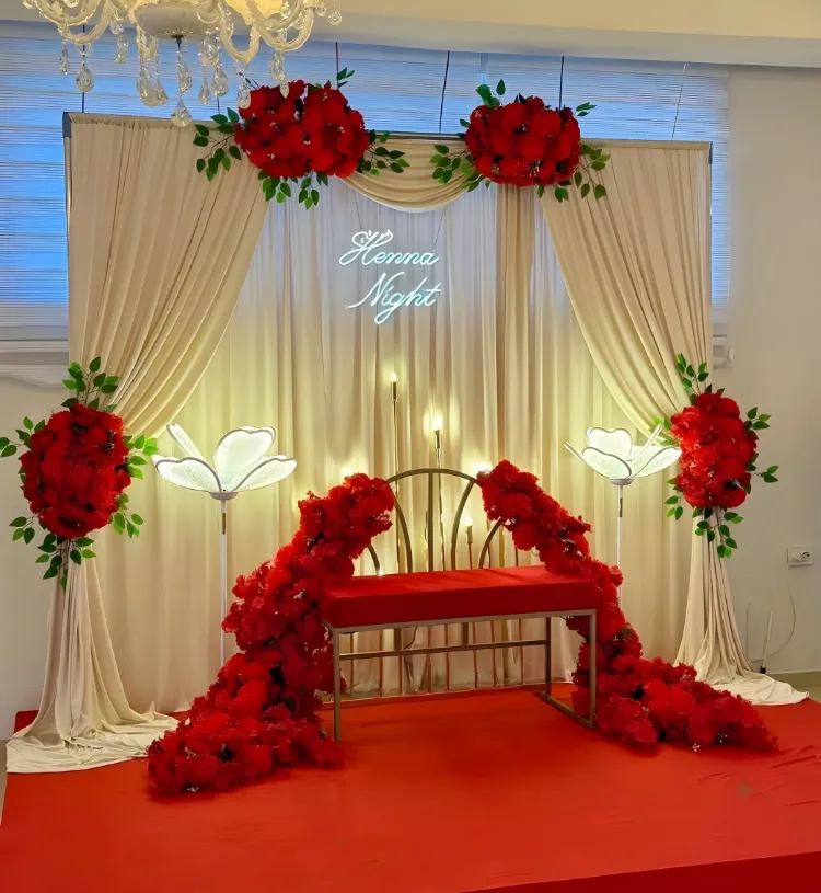 Luxury Henna Night Stage Decoration with Cream Drapes, Red Flowers and Neon Sign