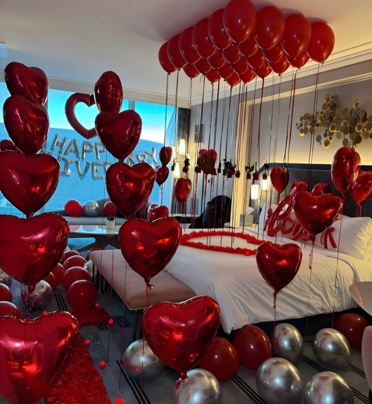 Romantic anniversary room decoration with heart balloons, rose petals and Happy Anniversary backdrop