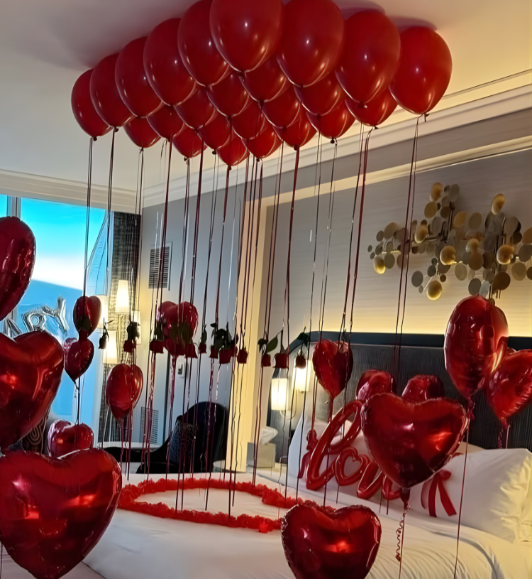 Romantic anniversary room decoration with heart balloons, rose petals and Happy Anniversary